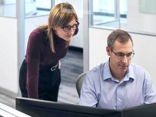 A group of professionals engaged in discussion, focusing intently as they share ideas around a conference table.